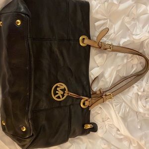 Black leather Michael Kors bag with tan handles and gold hardware